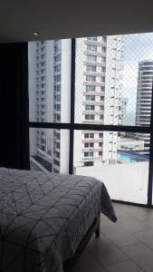 a bedroom with a bed and a large window at Room at the Sky in Panama City