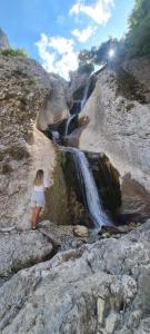 a woman standing on the rocks near a waterfall at Dhimitrulla Guest-House in Përmet