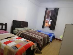 a bedroom with two beds and a window at EL SEÑORIAL in Lima