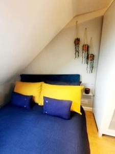 1 dormitorio con 1 cama con almohadas azules y amarillas en Alross studio flat / private bathroom, en Londres