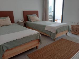 1 dormitorio con 2 camas y balcón en Aulaga en Villaverde