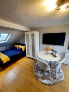 um quarto com uma mesa e cadeiras e uma cama em Alross studio flat / private bathroom em Londres
