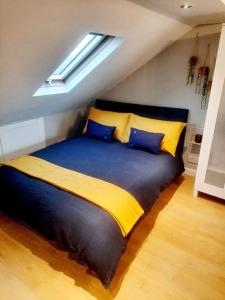 a bedroom with a large bed with blue and yellow sheets at Alross studio flat / private bathroom in London