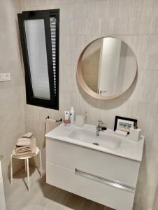 a white bathroom with a sink and a mirror at Aulaga in Villaverde
