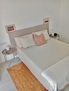 1 dormitorio con 1 cama blanca grande y 2 mesas en Aulaga en Villaverde