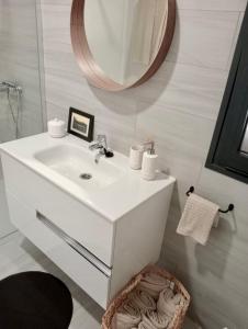 bagno con lavandino bianco e specchio di Aulaga a Villaverde