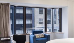 a living room with a blue chair and a large window at InterContinental Wellington, an IHG Hotel in Wellington