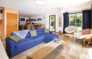 - un salon avec un canapé bleu et une table dans l'établissement Beautiful Home In Vagnas With Outdoor Swimming Pool, à Vagnas