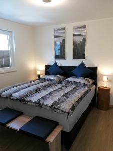 a bedroom with a large bed with blue pillows at Ostseetraum-H-7 in Hohwacht