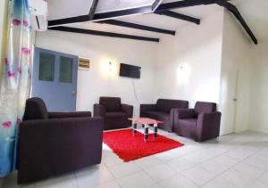 a living room with two couches and a red rug at Mohans Apartments in Nausori