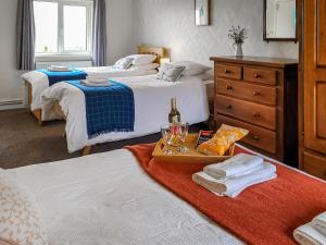 a hotel room with two beds with a tray with wine glasses at Bryn Boda in Nantglyn