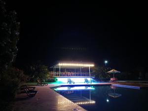 ein Schwimmbad in der Nacht mit einem Gebäude im Hintergrund in der Unterkunft Hotel campestre la Maria in Villavicencio