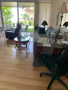 a living room with a couch and a table and chairs at Kihei Kai Nani 112 in Kihei