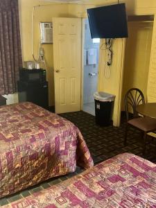 a hotel room with two beds and a table at Motel 301 in Tampa
