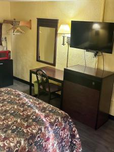 a hotel room with a bed and a desk with a television at Motel 301 in Tampa