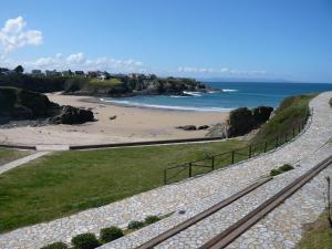 a road leading to a beach next to the ocean at Apartamentos Casa Germana in Tapia de Casariego