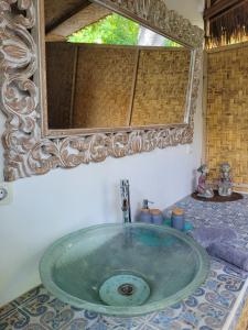 een wastafel in de badkamer met een grote spiegel erboven bij Gili Matiki in Gili Air