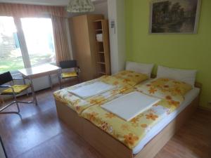 a bedroom with a bed and a table and a window at Bramkamp Pension in Dallgow
