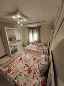 - une chambre avec 2 lits fleuris dans l'établissement Khaled new home, au Caire