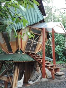 a tree house with a hammock in front of it at Kasaguadua - RESERVA NATURAL in Salento