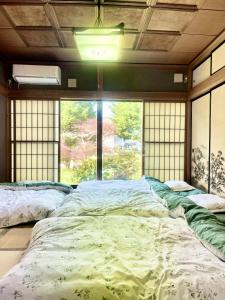 a large bed in a room with a large window at T&T Fujiyama Guest House in Fujiyoshida