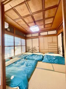 una stanza con quattro sacchi a pelo blu di T&T Fujiyama Guest House a Fujiyoshida
