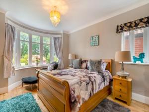 een slaapkamer met een bed en 2 ramen bij Seashells Peasholm in Scarborough