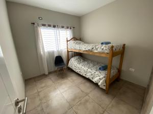 a bedroom with two bunk beds and a window at Mendoza Deptos apart in Guaymallen