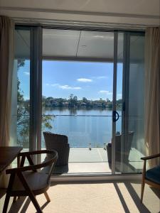 een kamer met een grote glazen deur met uitzicht op het water bij Nagambie Waterfront Motel in Nagambie