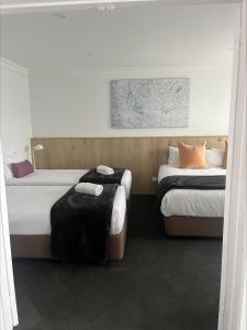 two beds in a hotel room with two beds sidx sidx sidx at Nagambie Waterfront Motel in Nagambie