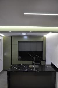 a kitchen with a black counter with a sink at City apartment 101 in Shkodër +34 photos