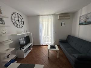 ein Wohnzimmer mit einer Couch und einer Uhr an der Wand in der Unterkunft Apartment Ivek in Mandre