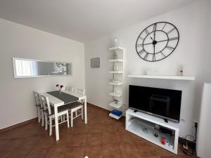 ein Wohnzimmer mit einem Tisch und einer Uhr an der Wand in der Unterkunft Apartment Ivek in Mandre