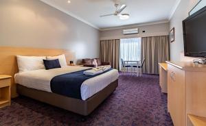 a hotel room with a bed and a flat screen tv at Albert Motel in Moree