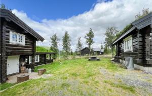 a yard between two log buildings with a yard at Stunning Home In Nord-torpa With Kitchen in Nord Torpa