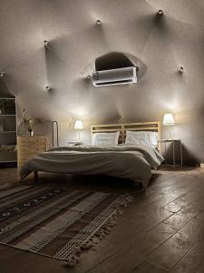 a bedroom with a large bed and two lamps at Albaha domes in Rahwat al Barr