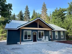 a small blue house with two chairs on a driveway at Luxe Mt. Rainier Lodge w/ Hot Tub-AC-Game Room in Ashford