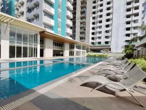 a swimming pool with lounge chairs in front of a building at Sebby Studio in Bacolod