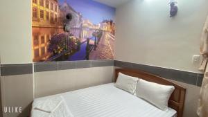 Phước Thịnh Hotel في فنغ تاو: سرير صغير في غرفة مع صورة على الحائط