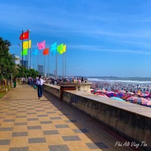 Phước Thịnh Hotel في فنغ تاو: مجموعة من الناس على الشاطئ مع أعلام ملونة