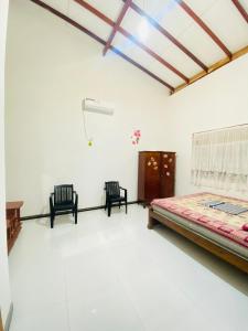 WariyapolaにあるSAKURA Guest House tourist onlyのベッドルーム1室(ベッド1台、椅子2脚付)