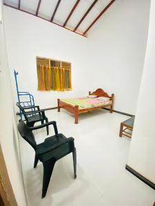 a living room with a chair and a bed at SAKURA Guest House tourist only in Wariyapola