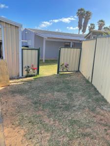 a fence with two gates with flowers in it at Central Shenton unit Outside Dog Friendly, near hospital in Geraldton