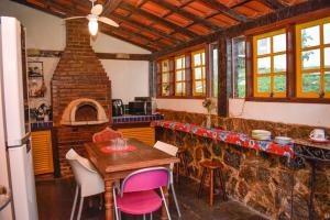 a kitchen with a table and a brick oven at Toca Geribá in Búzios