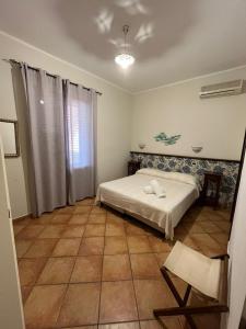 1 dormitorio con 1 cama y 1 silla en Dormo Da Lia Borgo San Nicola, en Mandra Capreria
