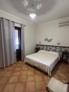1 dormitorio con 1 cama blanca en una habitación en Dormo Da Lia Borgo San Nicola, en Mandra Capreria