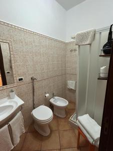 a bathroom with a toilet and a sink and a shower at Dormo Da Lia Borgo San Nicola in Mandra Capreria