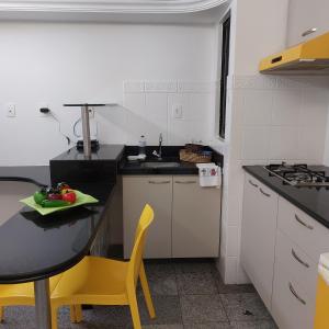 una pequeña cocina con mesa y silla amarilla en Lindo Apt em Boa Viagem en Recife