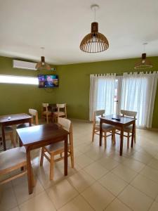 Cañas Suites Villa Cura Brochero في فيلا كورا بروشيرو: غرفة طعام مع طاولات وكراسي وتلفزيون