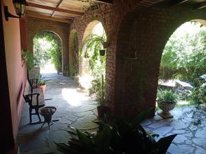 a courtyard with arches and plants in a building at Posada A Viagem in Tandil